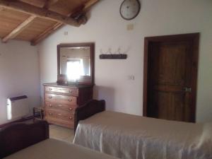 布萨拉拉色勒塔农家乐的一间卧室配有两张床、一个梳妆台和闹钟