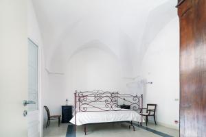 圣卡特琳娜迪纳德Villa nella Pineta的一间白色卧室,卧室内配有一张床铺,卧室内配有椅子