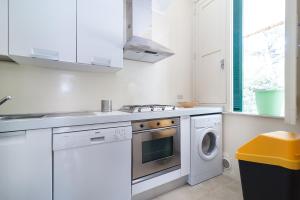 圣卡特琳娜迪纳德Villa nella Pineta的白色的厨房配有炉灶和洗衣机。