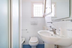 圣卡特琳娜迪纳德Villa nella Pineta的白色的浴室设有水槽和卫生间。