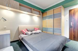 格但斯克Dom & House - Apartamenty Kamienice Nad Motławą的一间卧室配有一张带红色和白色枕头的大床