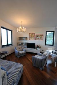 斯培西亚La Torretta Rosa的客厅配有沙发、椅子和吊灯