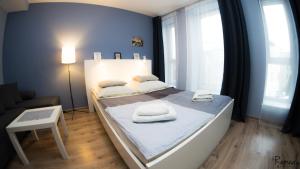 什切青Apartamenty Sedinum - Bryza的一间卧室配有一张床,上面有两条毛巾