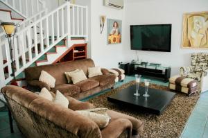 拉普拉亚蒂陶洛Villa Tauro Country Club的客厅配有两张沙发和一台电视机