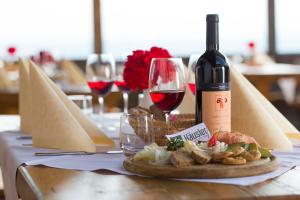 圣洛伦佐-迪塞巴托豪斯勒高山酒店的一张桌子,上面放着一瓶葡萄酒和一盘食物