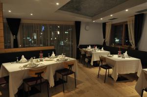 摩德纳迪-坎皮格里奥劳拉洛奇小屋酒店的用餐室配有带白色桌布的桌子