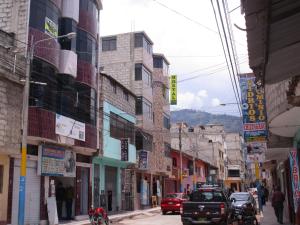 AbancayHostal Arcangel的一条繁忙的城市街道,有汽车和建筑