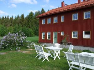 BjärtråAllsta Gård Kretsloppshuset B&B的红色房子前面的一张桌子和椅子