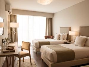 布宜诺斯艾利斯Dazzler by Wyndham Polo的酒店客房配有两张床和一张书桌