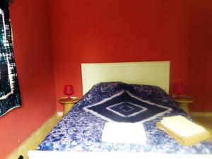 科洛里三琪巴黄色公寓的一间卧室设有蓝色的床和红色的墙壁