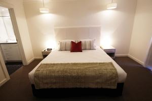 沃加沃加联排别墅公寓的一间卧室配有一张大床和两个红色枕头