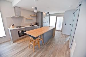德文港滨水公寓 的厨房铺有木地板,配有木桌。