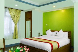 加德满都加德满都花园之屋酒店的一间卧室设有一张大床和绿色的墙壁