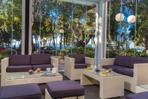茨里克韦尼察Hotel Crikvenica的庭院配有紫色的沙发、桌子和椅子