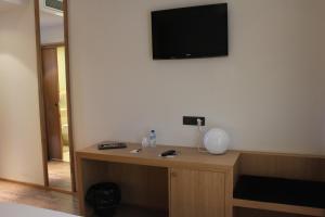 维多利亚-加斯特伊兹阿拉巴酒店的一间设有一张桌子的房间,墙上配有电视