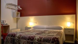 塞维利亚圣维森特2号旅馆的一间卧室配有一张带两个灯的床
