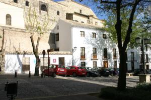 乌贝达Hostal Santa María de Úbeda的停在大楼前的一排汽车