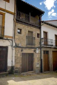 托尔纳瓦卡斯鲁拉雷蒂亚约瑟法公寓的一座古老的石头建筑,设有两扇门和一个阳台