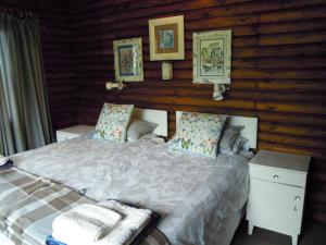 自然谷Forest Drive Holiday Home的一间卧室配有一张床,墙上挂着一些图片