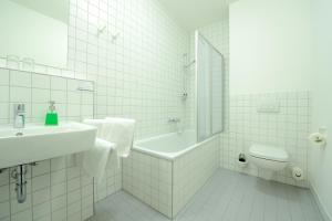 措森鲁内弗莱尔酒店的白色的浴室设有水槽、浴缸和卫生间。