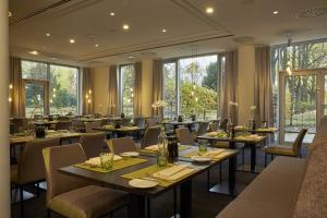 卡塞尔卡塞尔H4酒店的餐厅设有桌椅和窗户。