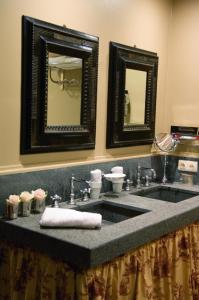 布鲁日伯尼非斯住宿加早餐高级宾馆的一间带水槽和两面镜子的浴室
