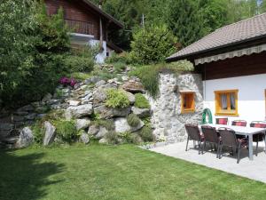 南达Chalet in Saclentse Basse Nendaz near Ski Area的石墙旁的天井配有桌椅