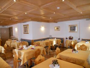 卡瓦莱塞Residence Garni Manuela的一间带桌椅和天花板的用餐室