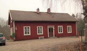 阿斯克松德Ljungås Gamla Skola的前面有长凳的红色房子