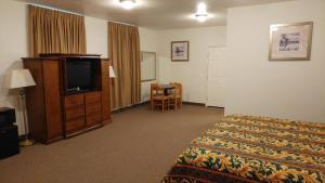 Manvel乡村丽晶酒店及套房的配有一张床和一台平面电视的酒店客房