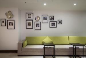 屏东县薇米文旅的客厅配有绿色沙发和墙上的照片