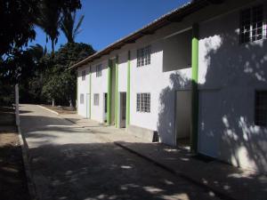乌巴雅拉Pousada Sitio Costa Verde的白色的建筑,设有绿门和人行道