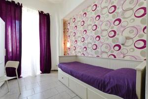 罗马Hostel Castello Maggiore的一间卧室配有一张紫色的床和一面圆墙