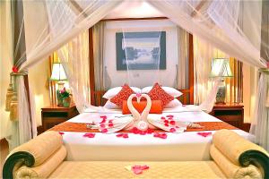 清迈Oriental Siam Resort - SHA Extra Plus Certified的一间卧室配有一张带鲜花的大床