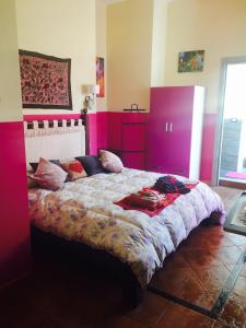 蒙德罗Mondello Room的卧室配有一张带粉红色墙壁的大床