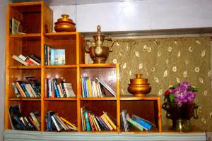 Nāmche BāzārHimalayan Lodge的书架上满书和花瓶
