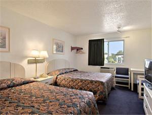 莱温芙丝Americas Stay Inn-Leavenworth的酒店客房设有两张床和电视。