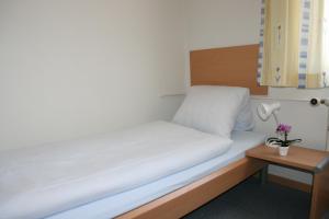 豪尔根格拉尼史霍夫酒店的小房间的床,配有台灯和桌子