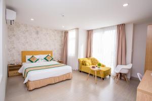胡志明市卡米拉酒店的一间卧室配有一张床、一把椅子和一张桌子
