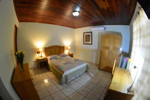 马那瓜Hotel Posada Don Pantaleon的一间卧室设有一张床和木制天花板