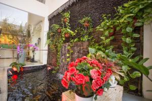 胡志明市卡米拉酒店的一间拥有砖墙、鲜花和瀑布的房间