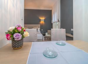 米兰布雷拉奢华套房公寓的一张桌子,上面有两盘盘子,花瓶上有花