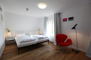 吕讷堡einzigartig - Das kleine Hotel im Wasserviertel的一间卧室配有一张床和一张红色椅子