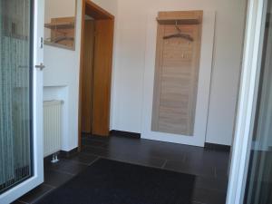 魏森贝格Ferienwohnung Wünsche的走廊上设有门,铺着黑色瓷砖地板