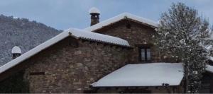 Bisaurri卡萨穆里亚冬青树酒店的屋顶上积雪的砖砌建筑