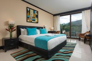 福尔图纳The Royal Corin Thermal Water Spa & Resort - Adults Only的一间带大床的卧室和一个阳台
