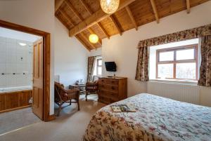乔利Parr Hall Farm, Eccleston的一间卧室配有一张床、一张书桌和一个窗户。