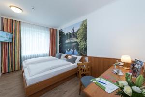 不莱梅威斯特伐利亚酒店 的一间卧室配有一张床、一张桌子和一张书桌