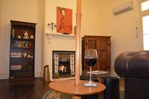 帕克斯Old Parkes Convent的客厅配有一张桌子,提供一杯葡萄酒