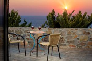 AmigdhalokeFálionSea-Sunset Views Villa Lefkothea with Private Pool near Elafonissi的两把椅子和一张桌子,两杯葡萄酒